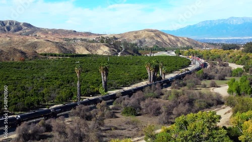 A UAV Drone View of a Cargo Diesel Electric Train Passing through Live Oak Canyon and a Forested Area Near Redlands, California photo
