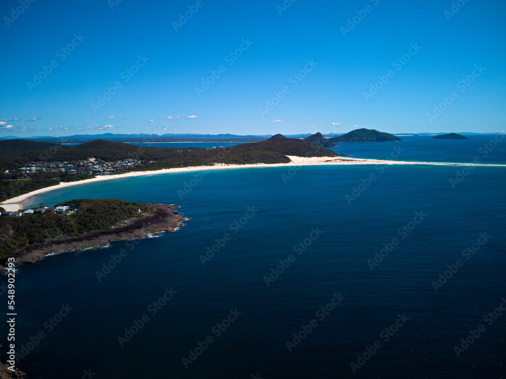 Fototapeta premium Drone photo of Fingal Bay and the spit leading to Shark Island on a bright sunny day