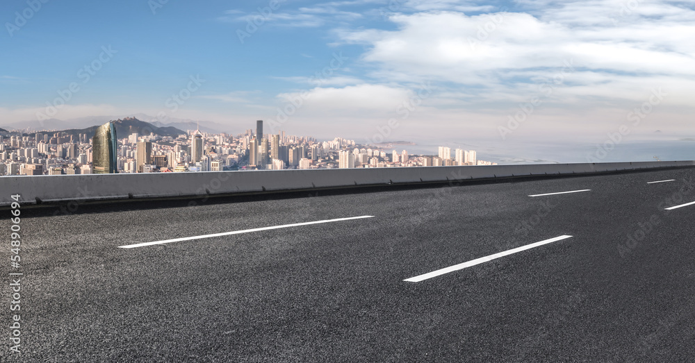 Fototapeta premium Background of asphalt pavement and urban architectural landscape skyline