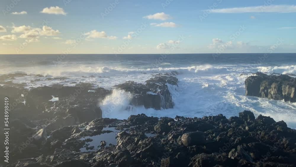 View of big waves at Sunset on the coast. Cliffs and rocky beach with thermal water. Stunning sea waves foam crashing on the volcanic stones, rock. View of 4K View of big waves at Sunset on the coast. Cliffs and rocky beach with thermal water. Stunning sea waves foam crashing on the volcanic stones, rock. View of 4K