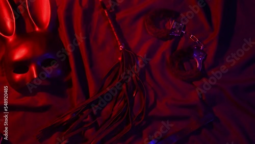 Handcuffs, leather whip flogger, mask and choker for BDSM sex with submission and domination. Concept of erotic adult sex toys