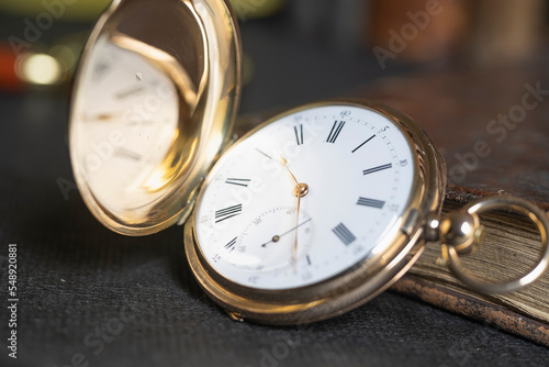 Gold pocket watch "Pavel Bure" on a gold pendant. Royal Russia. pocket watch on a dark background with books