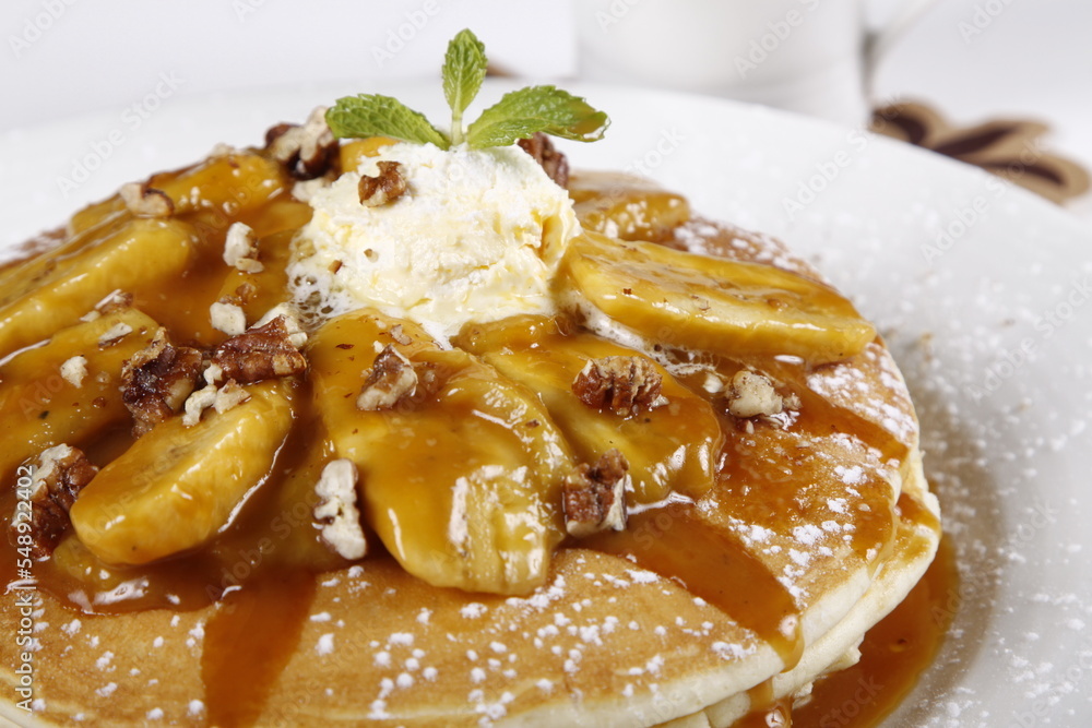 Pancake closeup, with bananas, walnuts, butter and syrup Pancake closeup, with bananas, walnuts, butter and syrup
