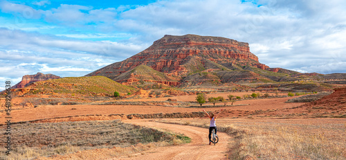 Woman cyclist riding with mountain bike in the desert ( sierra armantes, Aragon in Spain- Zaragoza province)