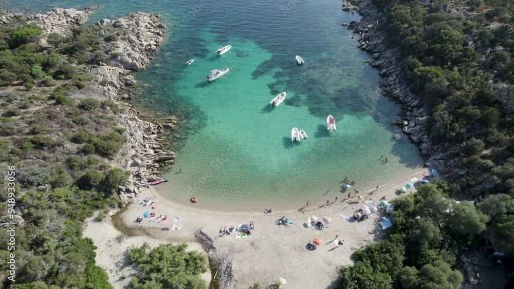 Las Cricas cove in Tizzano Beach on French Corsica Island Mediterranean Sea with boats and tourists bathing, Aerial tilt up reveal shot Las Cricas cove in Tizzano Beach on French Corsica Island Mediterranean Sea with boats and tourists bathing, Aerial tilt up reveal shot