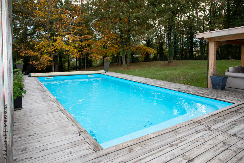 wooden corner of swimming pool with blue water