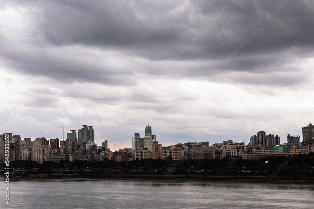 the city center across the river filled with black clouds
