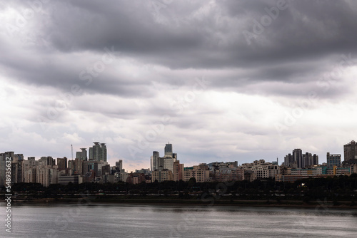 the city center across the river filled with black clouds © 완수 박