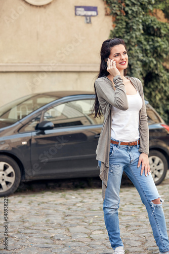 Young cute female using smartphone on the street. © astrosystem