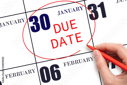 Hand writing text DUE DATE on calendar date January 30 and circling it. Payment due date