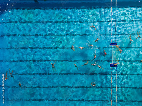 Fotografie Aerial drone top view of swimming pool with athletes training water polo