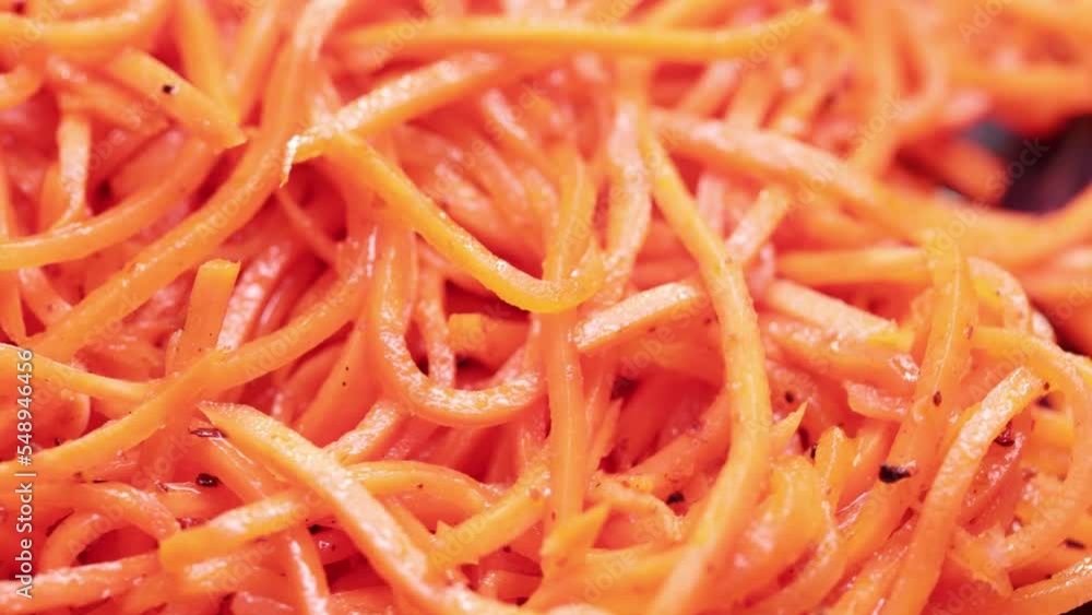 Bulk heap of Korean salad of chopped carrots, garlic, vegetable oil Bulk heap of Korean salad of chopped carrots, garlic, vegetable oil