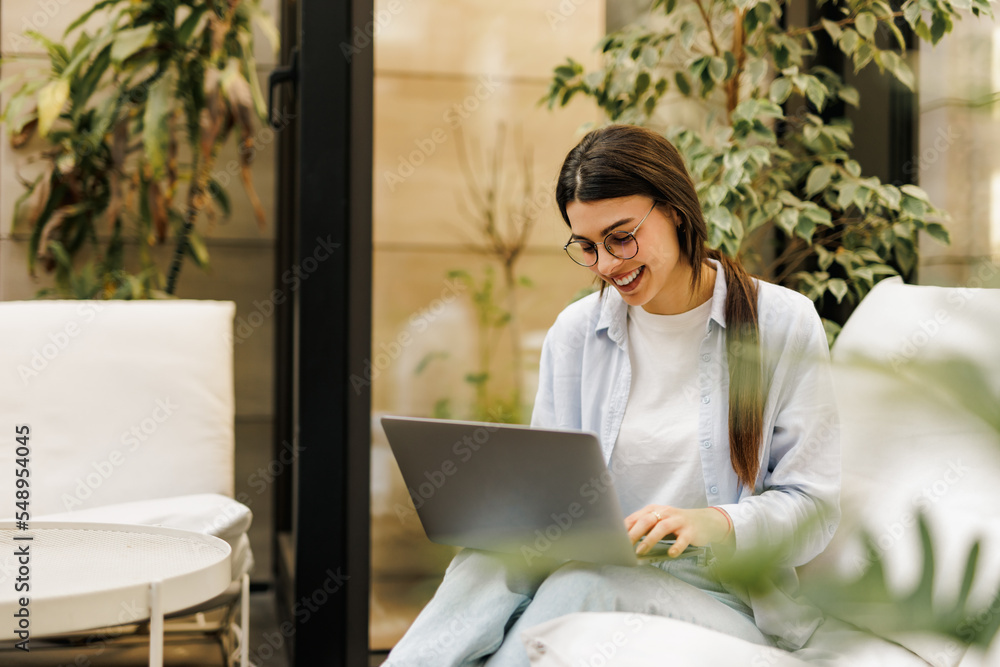 Smiling brunette female working online, over the laptop. Smiling brunette female working online, over the laptop.