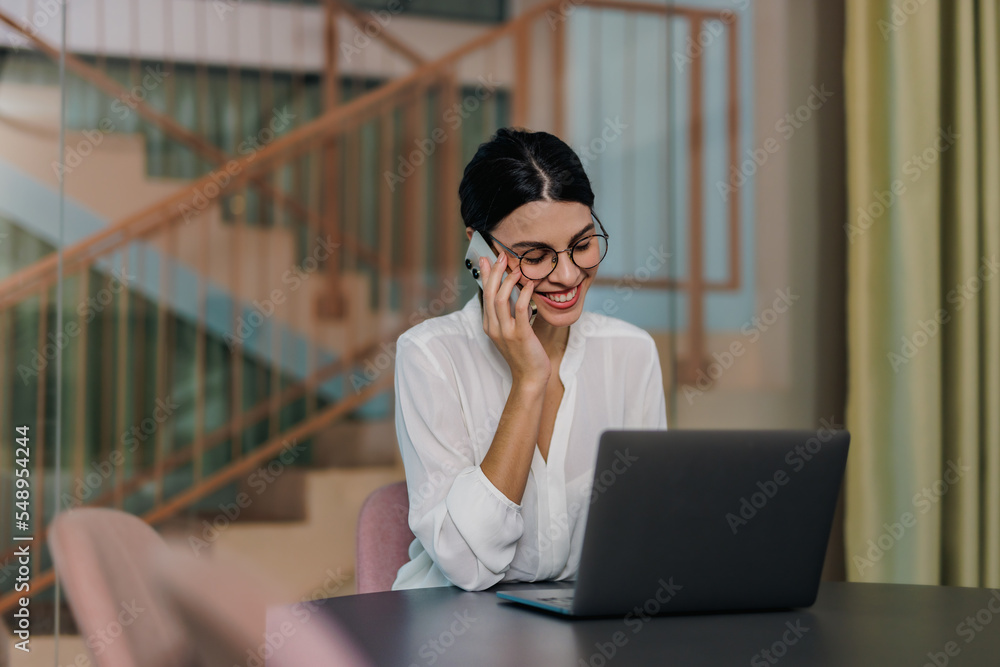 Business girl working online, making a phone call, at the office. Business girl working online, making a phone call, at the office.
