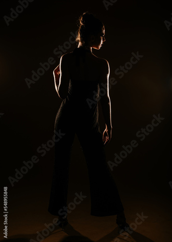 Girl in silhouette. Black sparkling overall