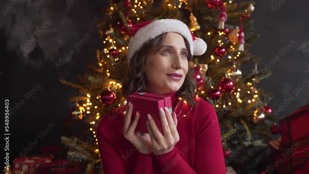 woman looks at a box with a gift, shakes it, tries to guess what is inside woman looks at a box with a gift, shakes it, tries to guess what is inside