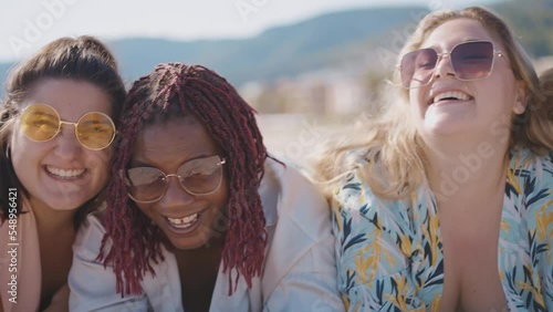 Cinematic storytelling footage of beautiful plus size women having fun at the beach in the summertime. Oversized big girls friends, representation of body positivity and body acceptance concepts photo