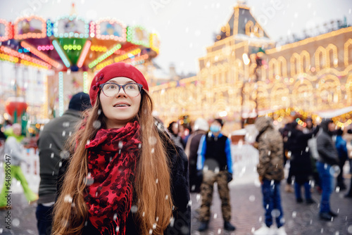 Winter portrait of young beautiful happy woman in wearing stylish warm clothes, bokeh lights. Concept travel Christmas holidays Europe city