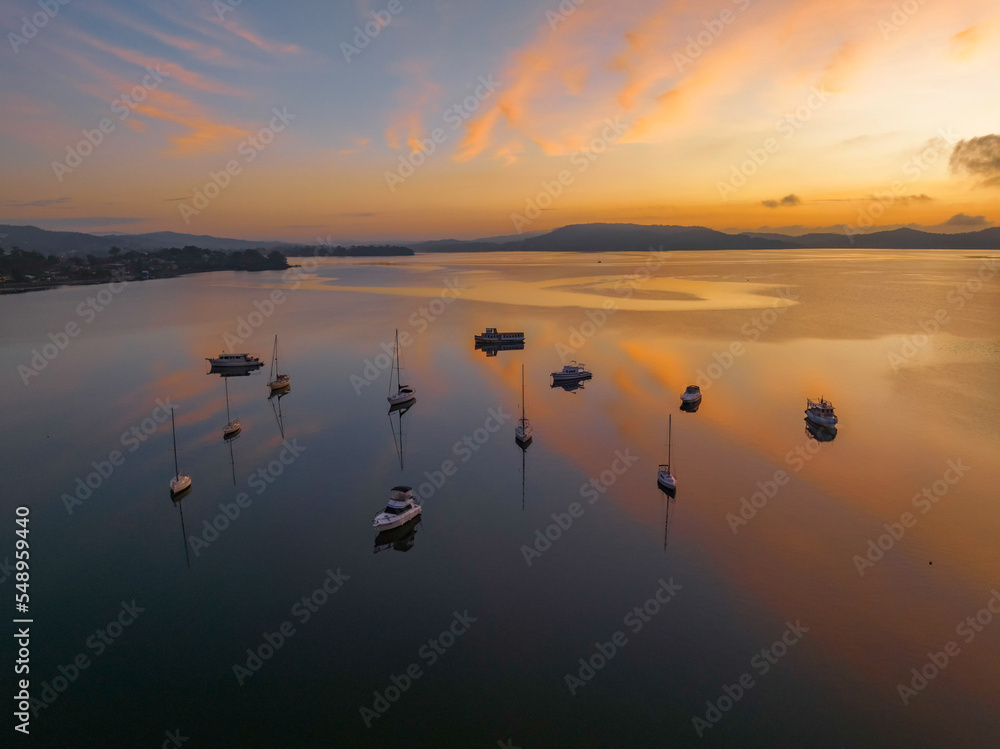 Sunrise over the water with fog, boats, clouds and reflections Sunrise over the water with fog, boats, clouds and reflections
