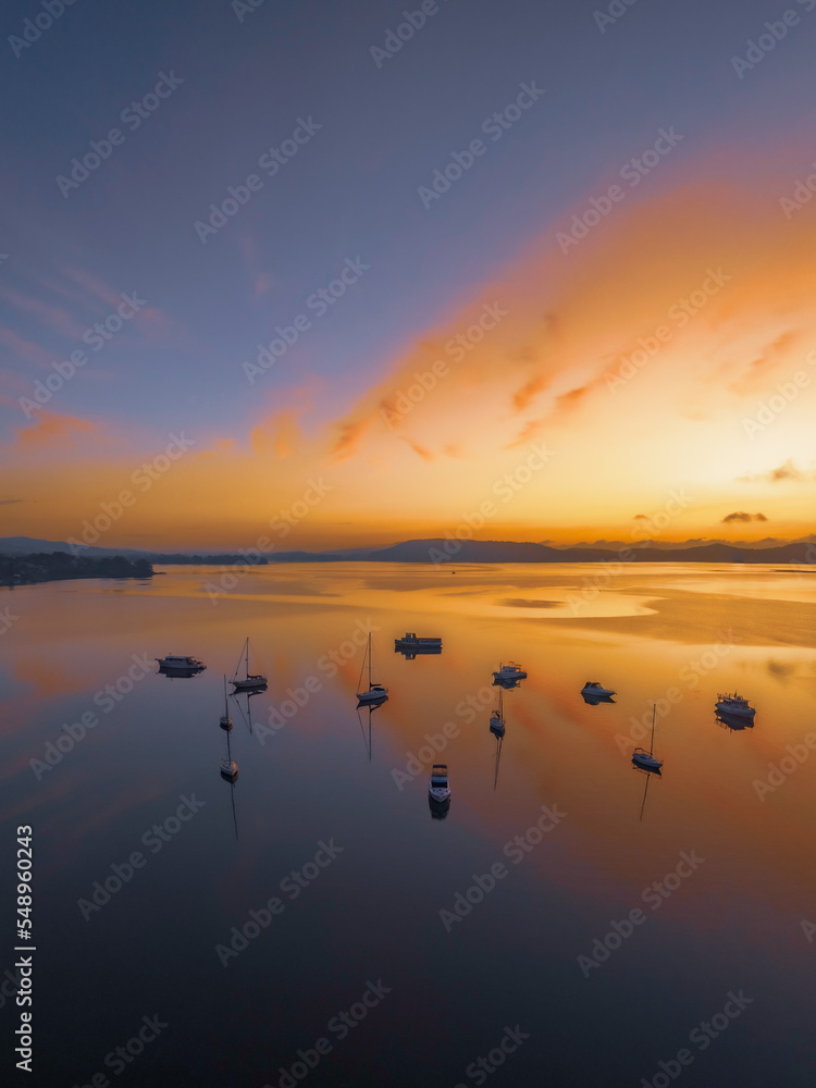Sunrise over the water with fog, boats, clouds and reflections Sunrise over the water with fog, boats, clouds and reflections