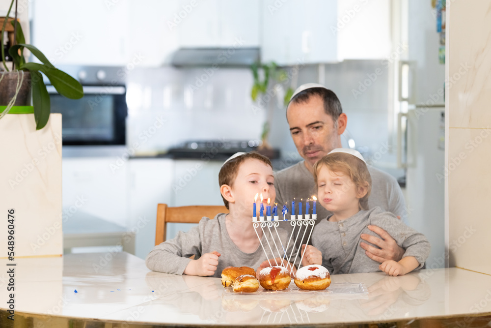 Father and sons with menorah celebrate hanukkah - Jewish religious holiday Father and sons with menorah celebrate hanukkah - Jewish religious holiday