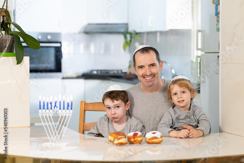 Father and sons with menorah celebrate hanukkah - Jewish religious holiday