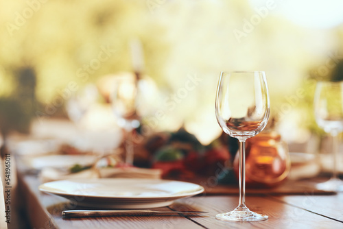 Empty wine glass, plate and cutlery on a table for a dinner, party or event at a restaurant. Glass, table setting and dinnerware for an outdoor luxury festive, holiday or celebration banquet or feast