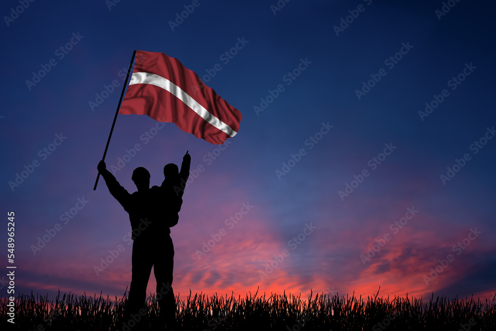 Father and son hold the flag of Latvia