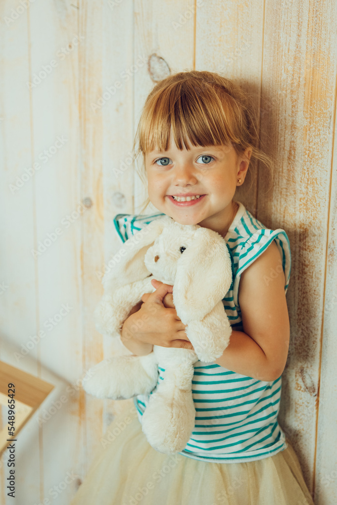 the child hugs a toy, a white bunny. High quality photo the child hugs a toy, a white bunny. High quality photo
