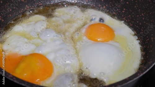 Woman cooking homemade Fried eggs in a pan for breakfast. Broken egg falls into the frying pan. Cooking Scrambled Eggs Frying Eggs on the Stove, The Concept of Protein Healthy Food and Diet.