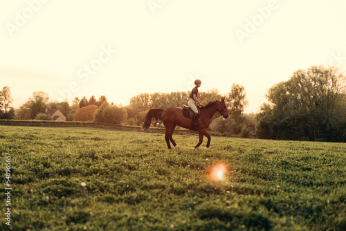 Fotografie professional horsewoman trotting with her horse at sunset