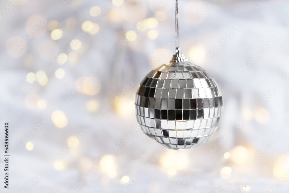 Obraz premium Xmas bauble on festive white background with bokeh lights. Creative Christmas backdrop with copy space. 2023