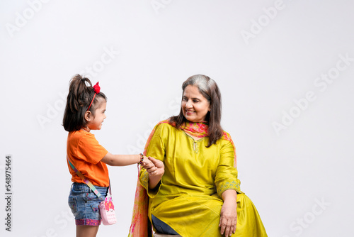 Indian grandmother with her granddaughter on white background.
