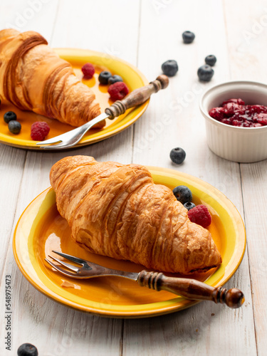 Tasty sweet croissant with blueberries and raspberries