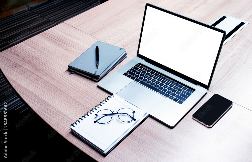 Top view white screen on display laptop with notebook and glasses on table in meeting room Top view white screen on display laptop with notebook and glasses on table in meeting room