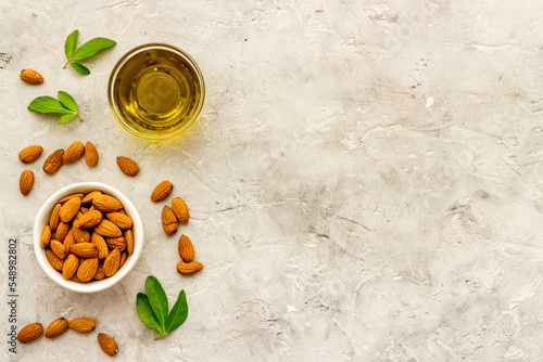 Almond nuts and almond oil in glass jar. Organic food and cosmetic background