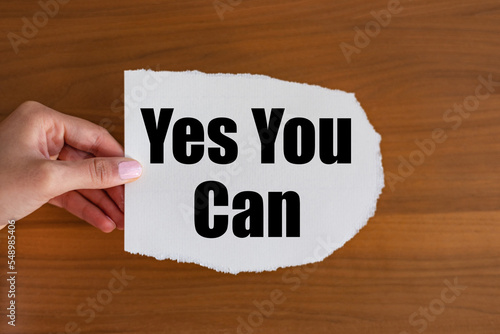 Yes you can. Woman hand holds a piece of paper with text. Motivation and inspiration.