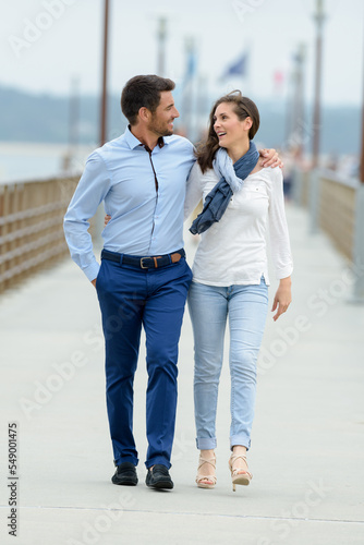 couple embracaing while walking along the promenade