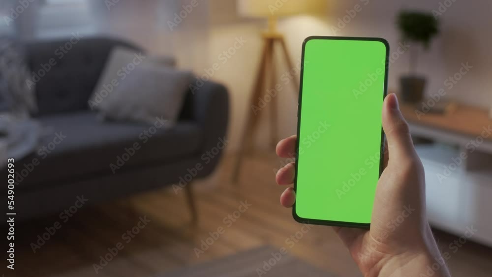 Handheld Camera: Point of View of Man on Living Room at Night Holding Chroma Key Green Screen Smartphone Watching Content Without Touching or Swiping. Boy Using Mobile Phone, Browsing Internet Handheld Camera: Point of View of Man on Living Room at Night Holding Chroma Key Green Screen Smartphone Watching Content Without Touching or Swiping. Boy Using Mobile Phone, Browsing Internet