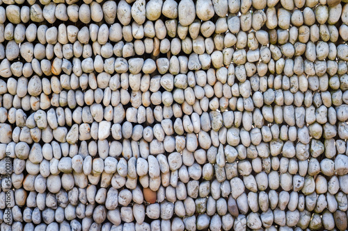 wall of pebbles piled up forms abstract pattern