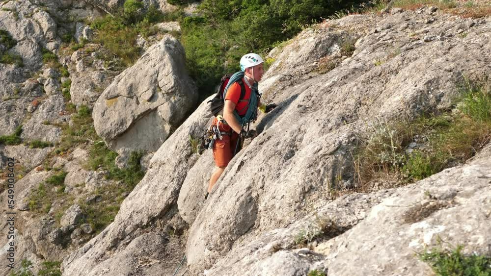 Young male climber climbs a mountain on a difficult route Young male climber climbs a mountain on a difficult route