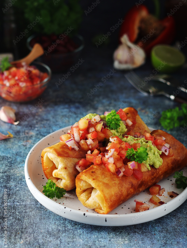A typical dish of Mexican cuisine - Chimichanga, made of tortilla with different ingredients A typical dish of Mexican cuisine - Chimichanga, made of tortilla with different ingredients