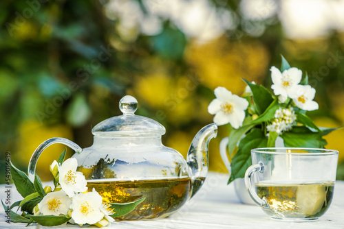 Philadelphus or garden jasmine flowers, healthy herbal tea cup of hot tea. Romantic dinner with therapeutic fragrant tea.