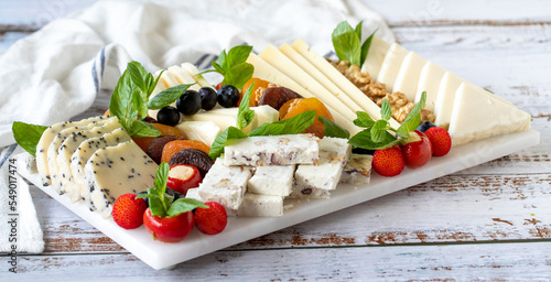 Mixed cheese plate on wood floor. Delicious assortment of cheeses. Camembert, Brie, Parmesan blue cheese, goat