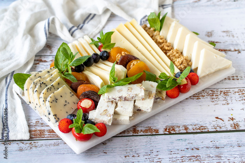 Mixed cheese plate on wood floor. Delicious assortment of cheeses. Camembert, Brie, Parmesan blue cheese, goat
