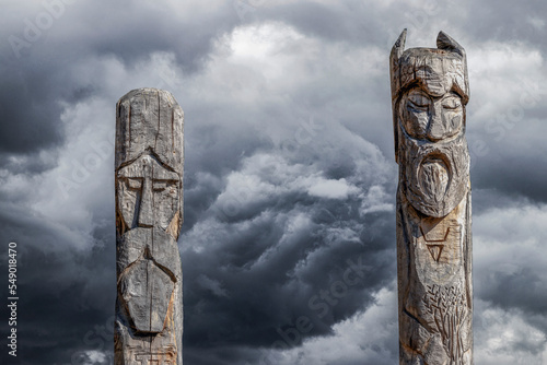 Northern lands. A pagan temple in the taiga with two wooden idols. The image of pagan gods is carved on wooden logs.