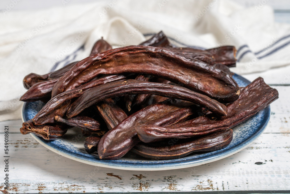 Carob on wood background. Healthy food. close up Carob on wood background. Healthy food. close up