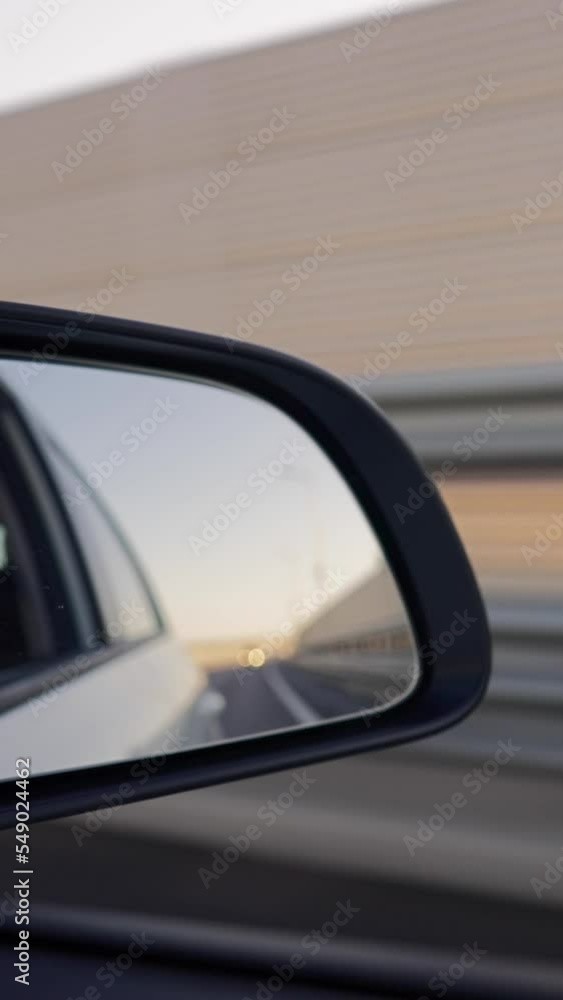 Vertical Video, View from of the Side Mirror the Inside of a Driving Car Along the Highway in a Sunny Day. Concept of Vehicles and Transport. No People. Vertical Video, View from of the Side Mirror the Inside of a Driving Car Along the Highway in a Sunny Day. Concept of Vehicles and Transport. No People.
