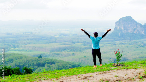 The concept of exercise and relaxation after stressful work. Asian man happily exercising in the mountains in Thailand