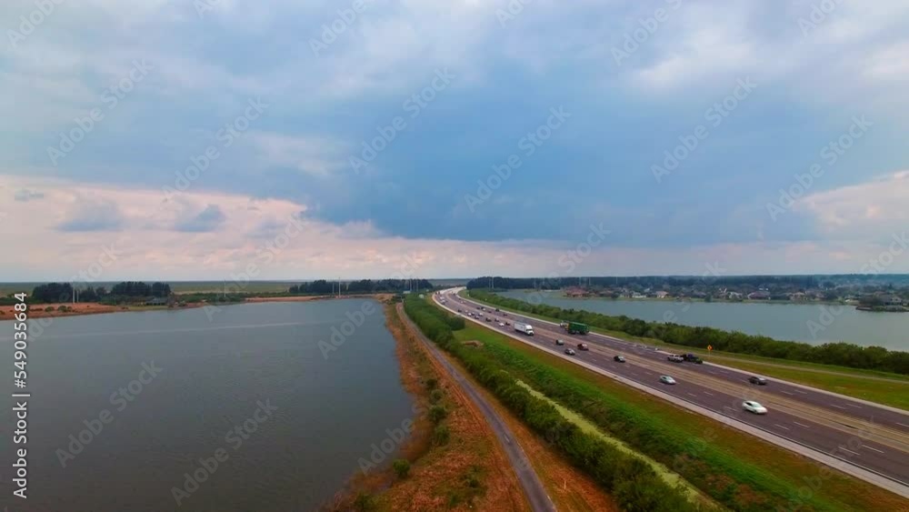 Aerial Forward Shot Of Vehicles Moving On Roads Amidst Rippled Sea Under Cloudy Sky - Daytona Beach, Florida Aerial Forward Shot Of Vehicles Moving On Roads Amidst Rippled Sea Under Cloudy Sky - Daytona Beach, Florida